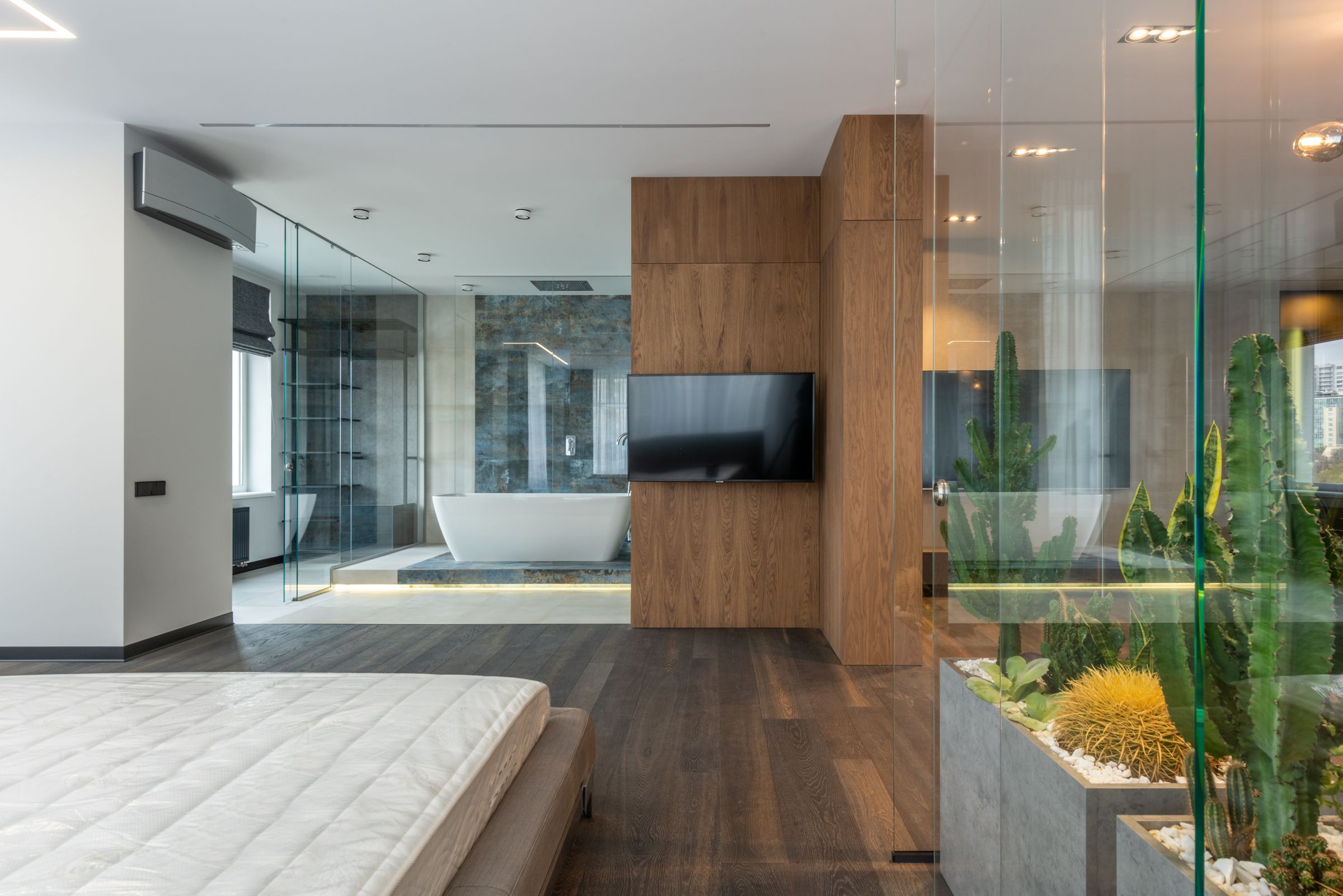 Primary bedroom with a low bed, oak wall panel and floor-to-ceiling curtains