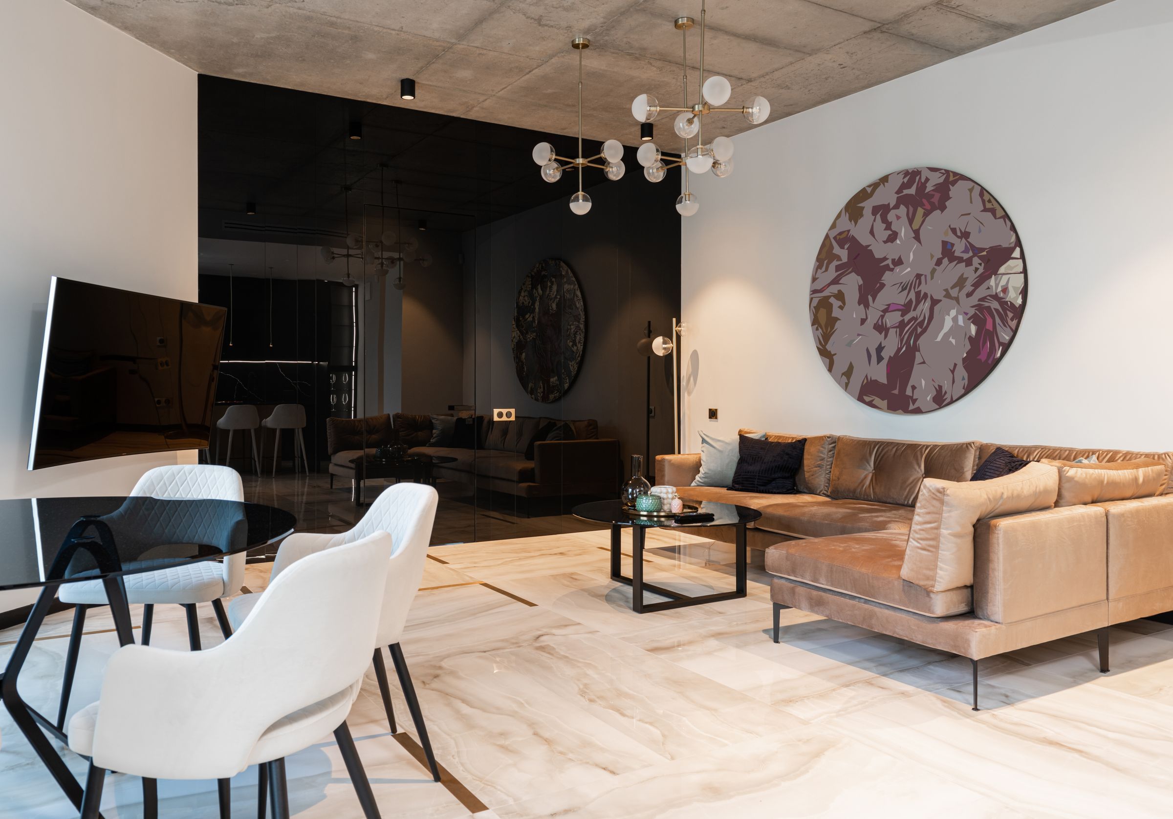 White upholstered chairs at a glass table, with the sectional behind them