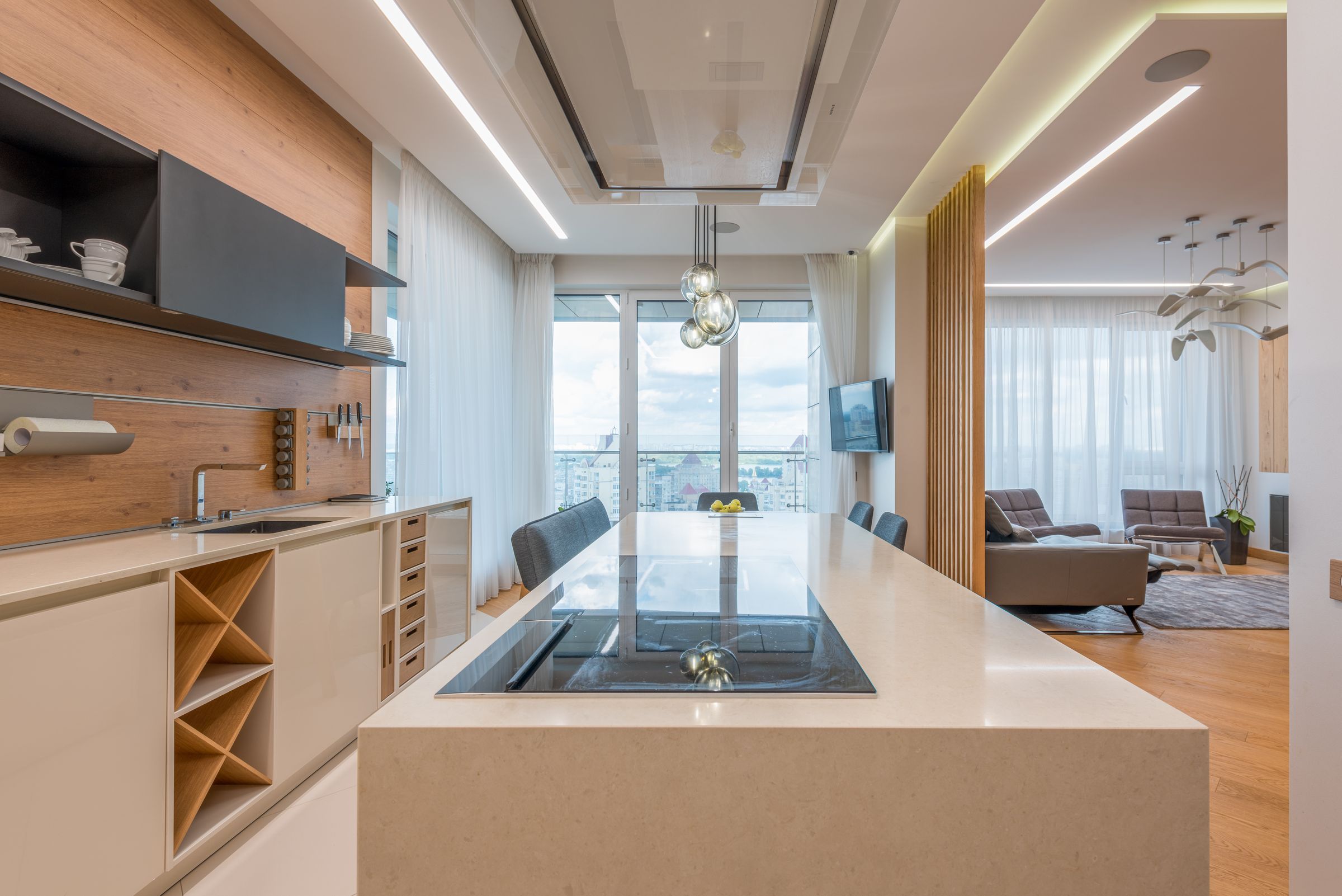 Stone kitchen island with a flush cooktop, facing the living room and the windows