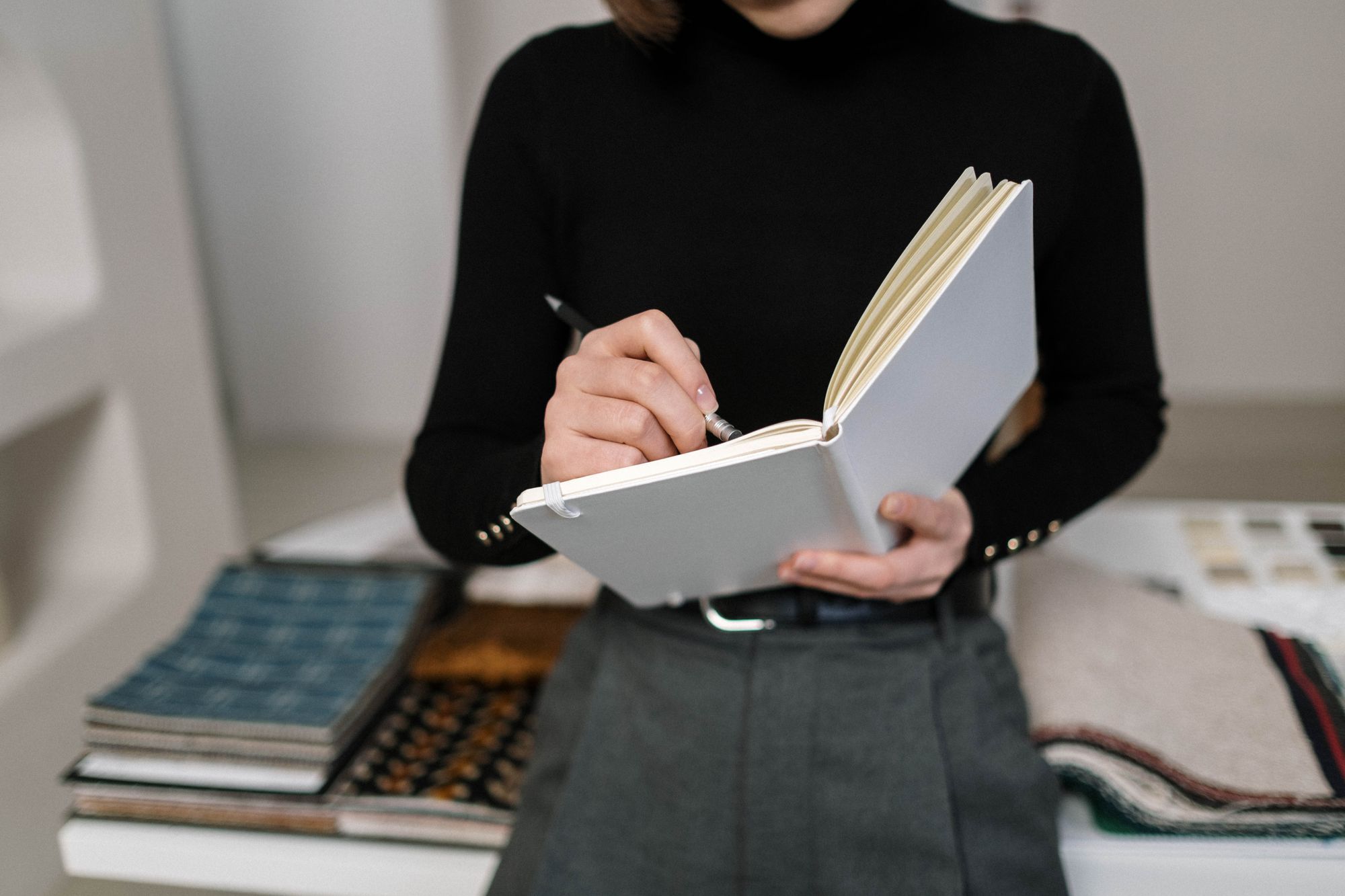 Mimi Sasson taking notes over fabric and tile samples in her studio